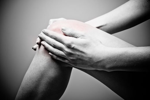woman holding hurt knee